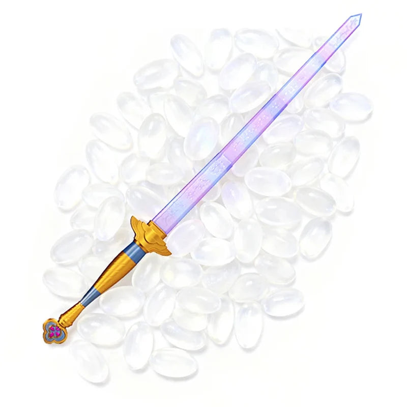 A purple and silver Lumi Symbol sword cosplay prop lying on a bed of clear, oval-shaped plastic beads.