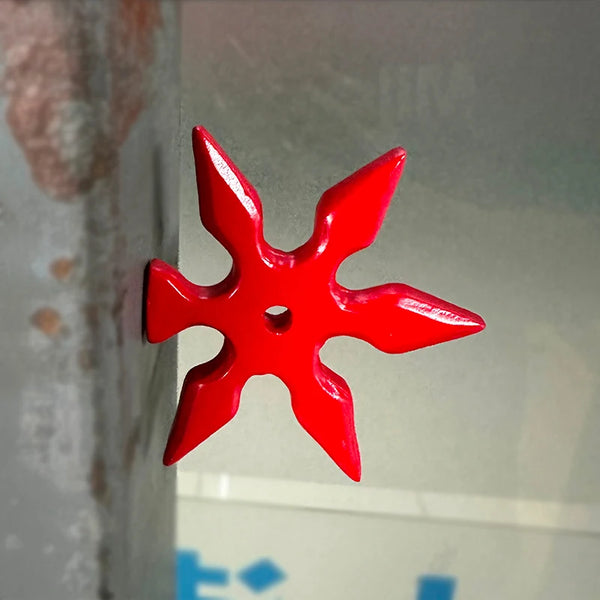 A bright red, star-shaped 3D axe fridge magnet is displayed against a light gray background.