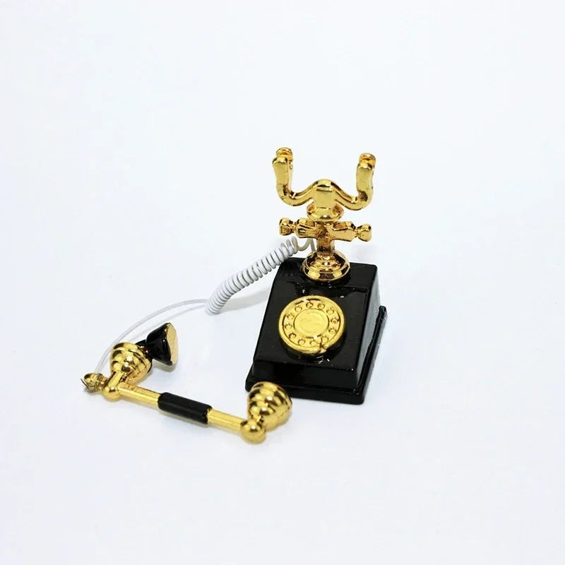 A vintage rotary desk phone miniature decor with a black base and brass components.