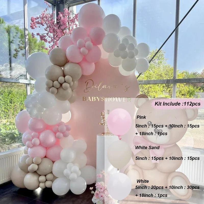 A pink and beige balloon garland arch kit featuring various sized balloons for a baby shower decoration.