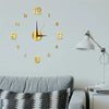 A round gold-colored wall clock with Roman numerals and hands is mounted on a light gray wall above a sofa.