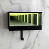 A black rectangular keychain holder with an LED tunnel effect illuminating a narrow, reflective tunnel.