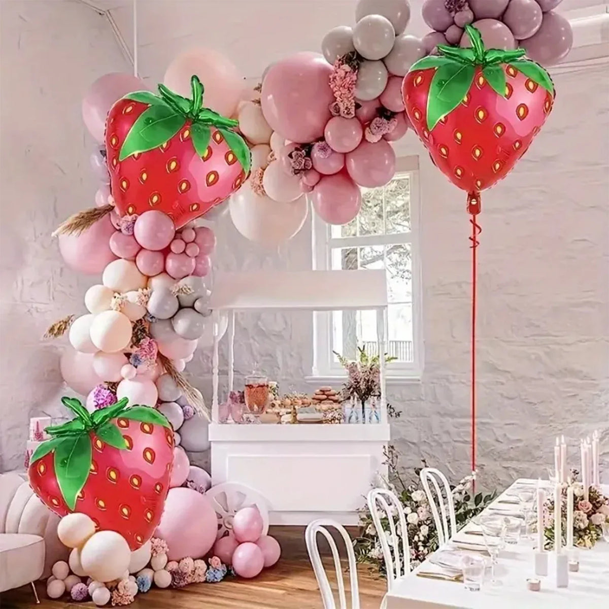 A display of pink and white balloons featuring strawberry shapes for a party decoration.