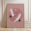 Pink canvas wall art featuring a white crane in flight against a pink circle and a small moon.