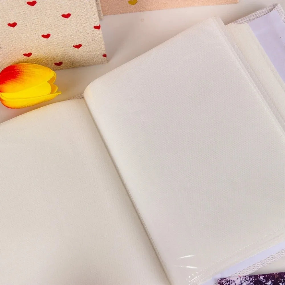 A white laminated photo album with a clear cover and a page showing a blank photo pocket.