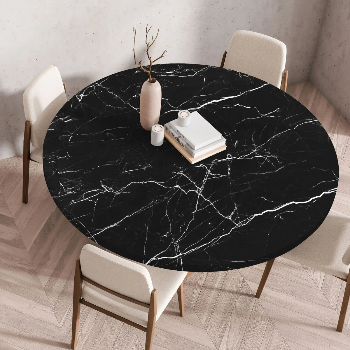 A round black marble print tablecloth is set on a wooden table with white chairs.