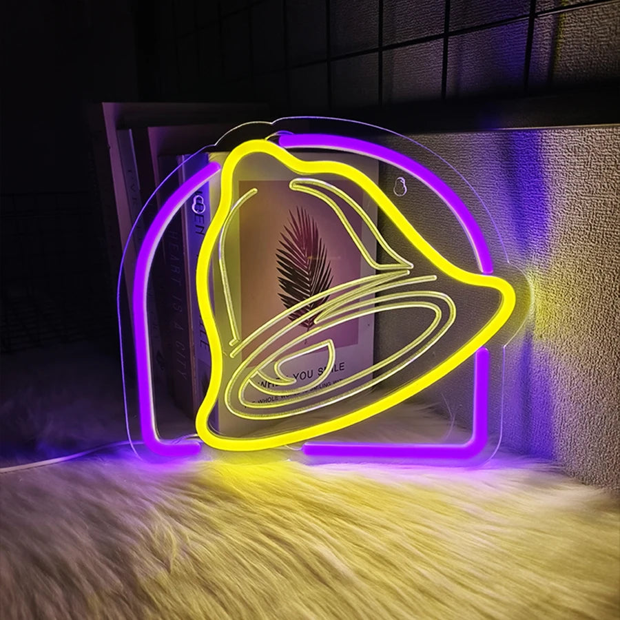 A neon yellow bell-shaped sign glows purple and yellow on a surface.