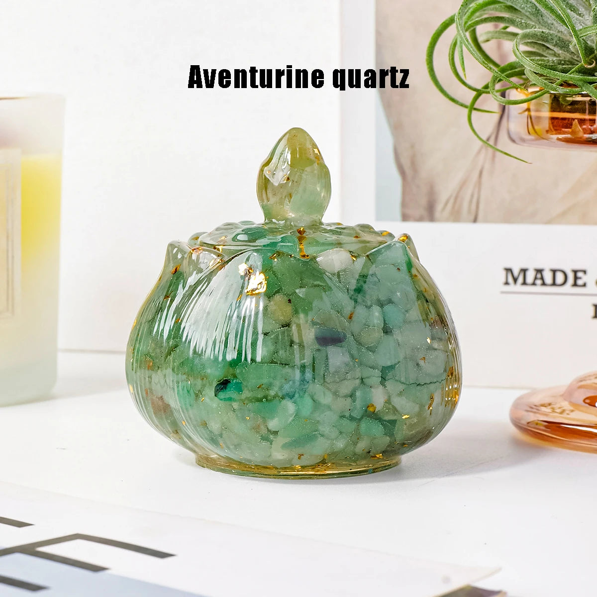 A green aventurine quartz bowl with a pointed top sits on a white surface.