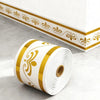 Roll of white and gold self-adhesive PVC skirting board trim with decorative scrollwork