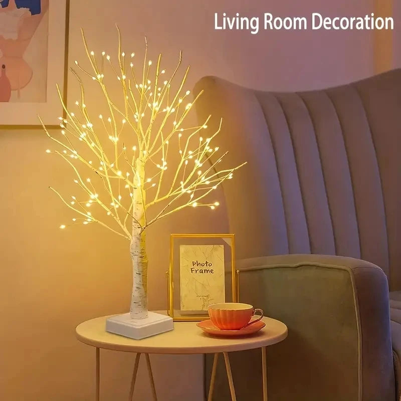 A tall, illuminated birch tree decorative light display on a table in a living room setting.