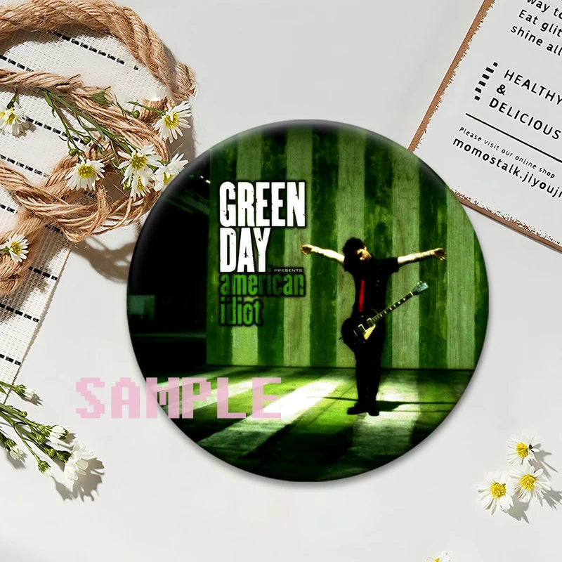 A button pin featuring a green striped background with a silhouette of a person playing a guitar.