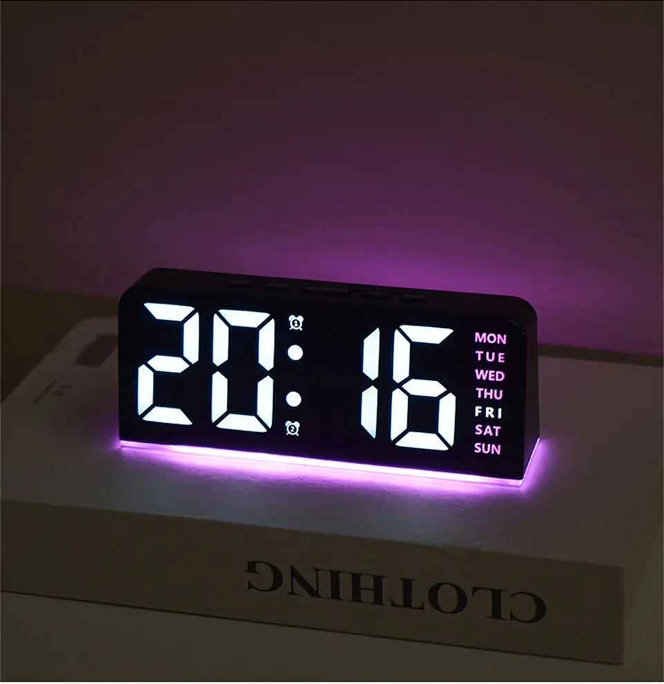 Reloj de alarma LED digital mostrando 20:16 en una superficie blanca con retroiluminación púrpura.