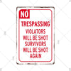 A vintage red and white metal warning sign with the text NO TRESPASSING VIOLATORS WILL BE SHOT SURVIVORS WILL BE SHOT AGAIN