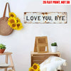 A rustic metal sign with the text LOVE YOU BYE mounted on a white wall, surrounded by potted plants and wooden furniture.