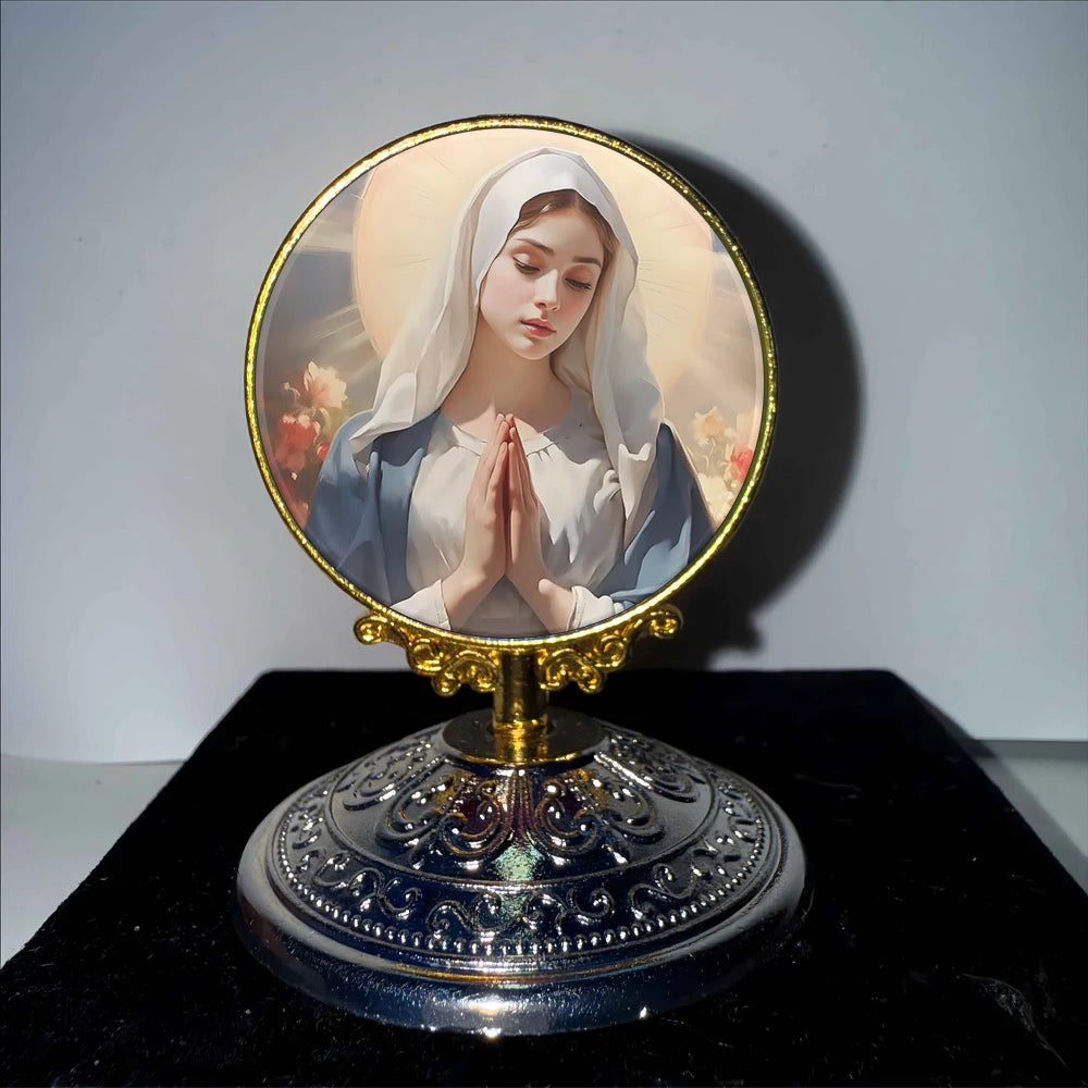 A round religious ornament featuring a depiction of the Virgin Mary with folded hands against a light background.