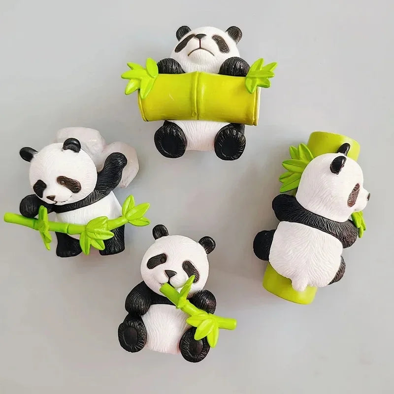 Three adorable panda figurines holding a yellow leaf-shaped object, used as fridge magnets.