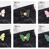 Six variations of pearl butterfly waist tightener buttons for jeans in black, pink, and lime green.