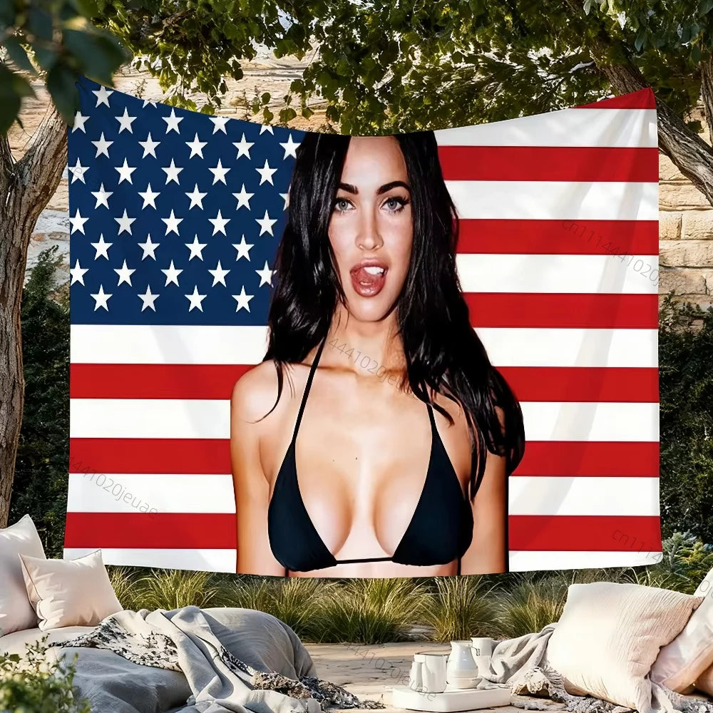 A woman wearing a black top posing in front of a pink and white American flag tapestry.