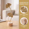 A golden ginkgo leaf ornament crafted from wood stands on a wooden base.