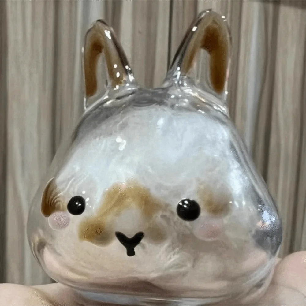 A clear glass figurine shaped like a rabbit with brown accents and black eyes.
