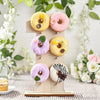 A wooden number display stand featuring donuts and cupcakes for desserts.