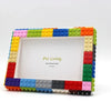 A colorful building block frame kit with a white photo area and surrounding blocks.