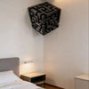 A dark, three-dimensional optical illusion cube wall decal featuring an impossible maze pattern mounted on a white wall.