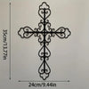 Black metal cross wall decor with ornate scrollwork, measuring 24cm long and 35cm high.