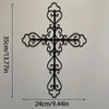 Black metal cross wall decor with ornate scrollwork, measuring 24cm by 35cm.