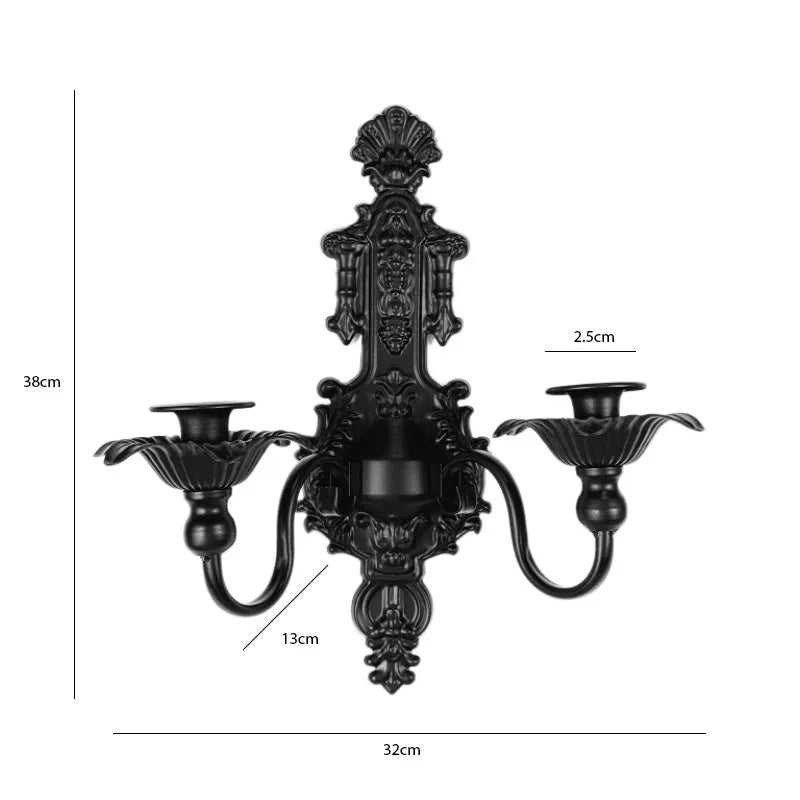 Vintage black wall pendant candle holder with ornate detailing and a curved arm.