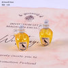 Two miniature resin magic potion bottles with yellow liquid and black bird labels for dollhouse decor