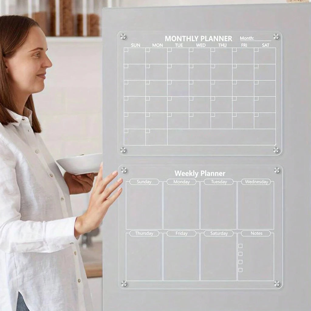 A woman stands next to a gray magnetic acrylic dry erase fridge planner showing monthly and weekly layouts.