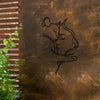 A black silhouette of a woman embracing a cat is etched onto a textured, bronze-colored metal surface.