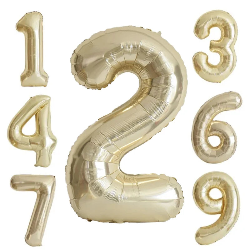A set of large champagne gold foil number balloons forming the numbers 1 through 9.
