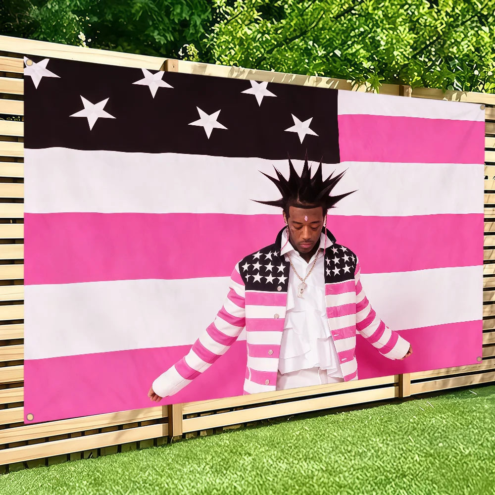 A person wearing a striped jacket stands in front of a large American flag banner featuring pink and white stripes and stars.