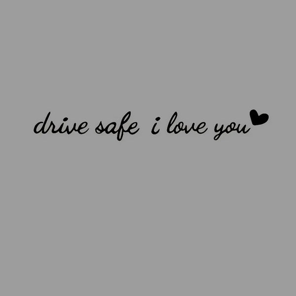 Black script text on a gray background that reads drive safe i love you with a small heart.