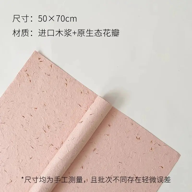 Pink decorative packaging paper with a rolled edge showing the texture of flower petals