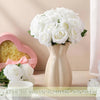 A bouquet of white artificial silk roses in a light beige vase creating a warm and romantic atmosphere.