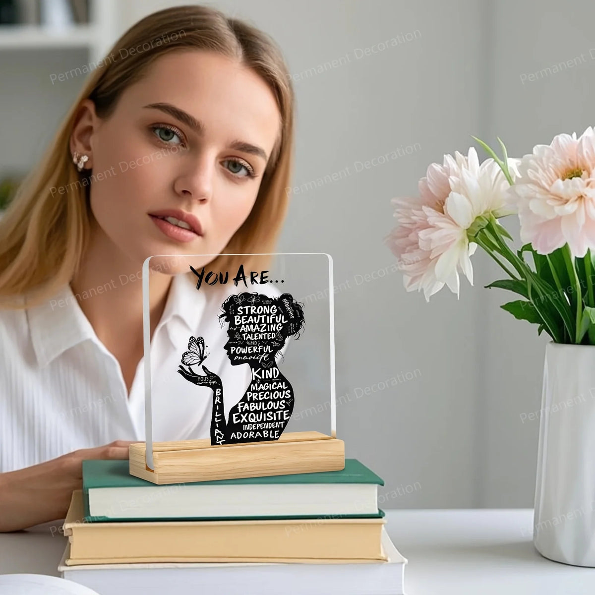 A woman holds an acrylic positive affirmation desk decor sign featuring the text You Are Strong Beautiful Amazing Talented Po