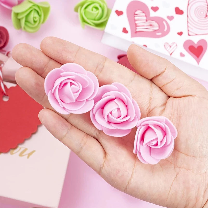 Una mano sostiene varias decoraciones de rosas artificiales rosas sobre un fondo rosa claro.