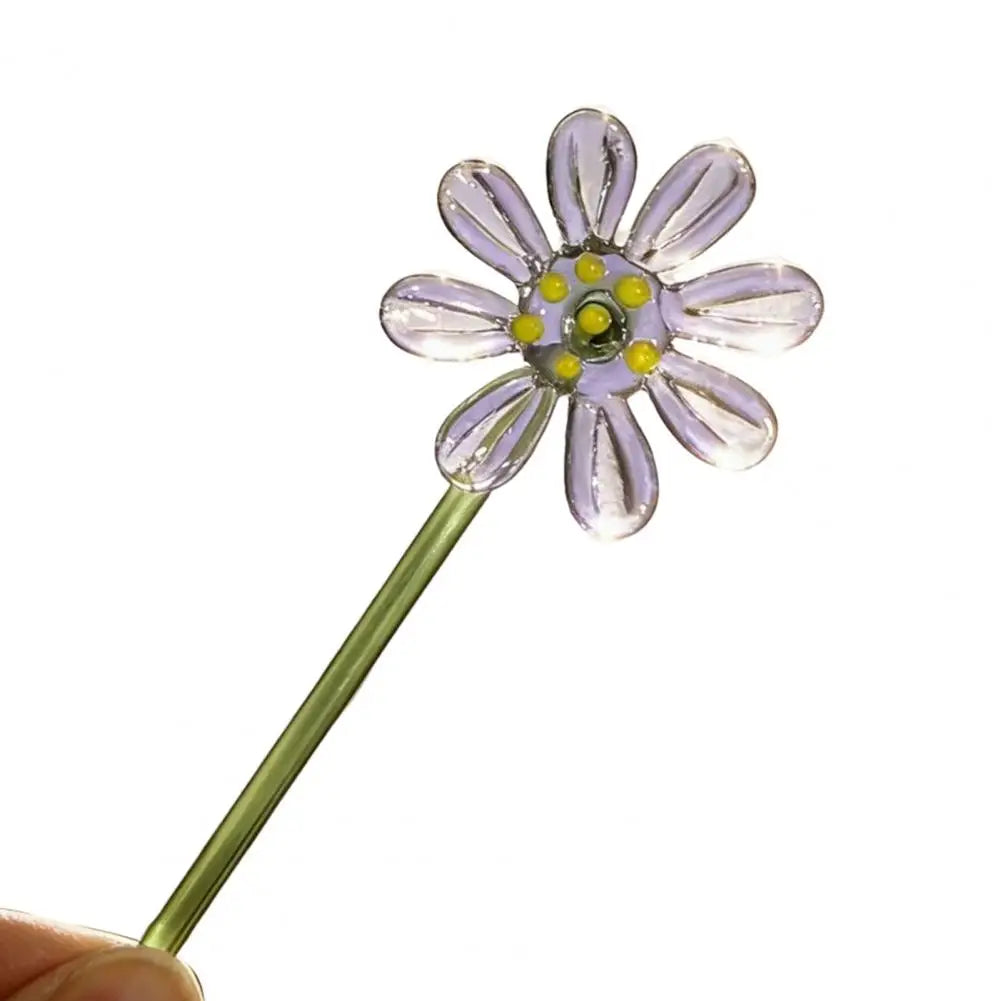 Handcrafted blue glass flower sculpture with a green stem and yellow center