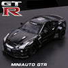 A black 1:32 scale diecast GTR sports car model with racing decals displayed on a dark background.