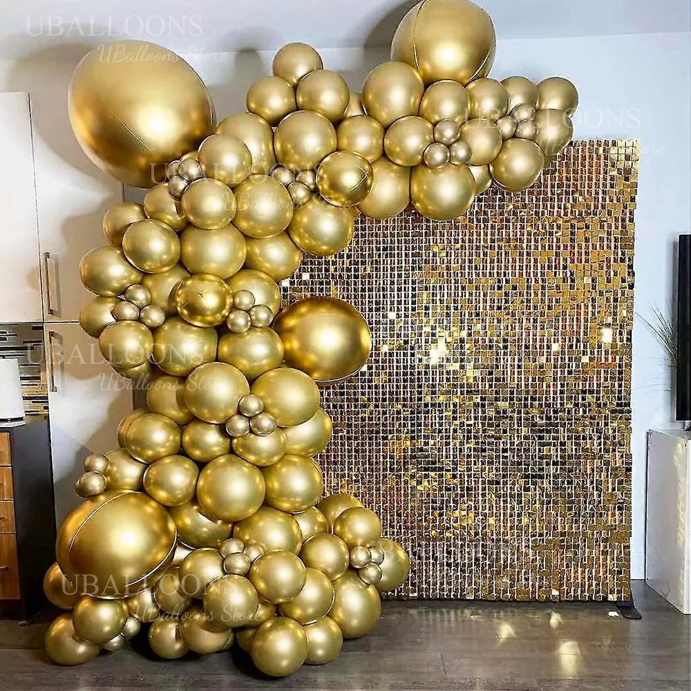 A large balloon garland made of metallic gold balloons decorated against a textured gold background.