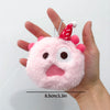 Pink fluffy plush keychain with a red conical ear and clear photocard holder being held by a hand