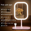 A pink LED touch makeup mirror with a large oval frame and a light pink base.