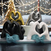 A display of gold, silver, and black heart hand gesture sculptures for home decor.