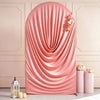A pink stretchy spandex arch cover draped elegantly with peach floral accents for weddings and events.