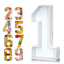 A set of colorful cardboard numbers 23456789 and a large number 1 displayed on a white stand.