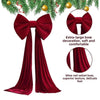A deep red velvet Christmas tree bow with long streamers and a satin drape.
