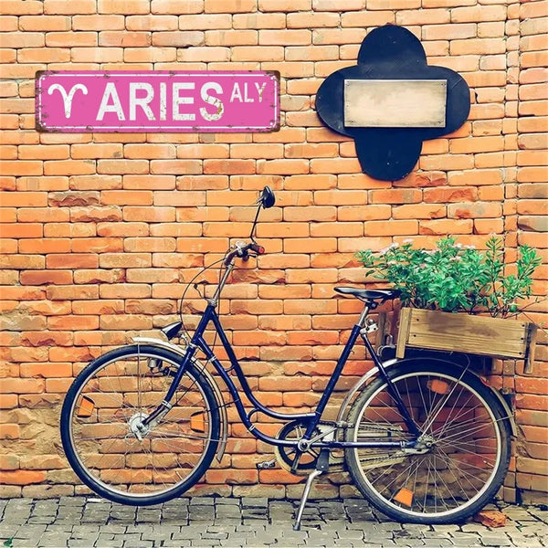 A vintage bicycle is parked against a brick wall with a purple sign reading YARIESALY.